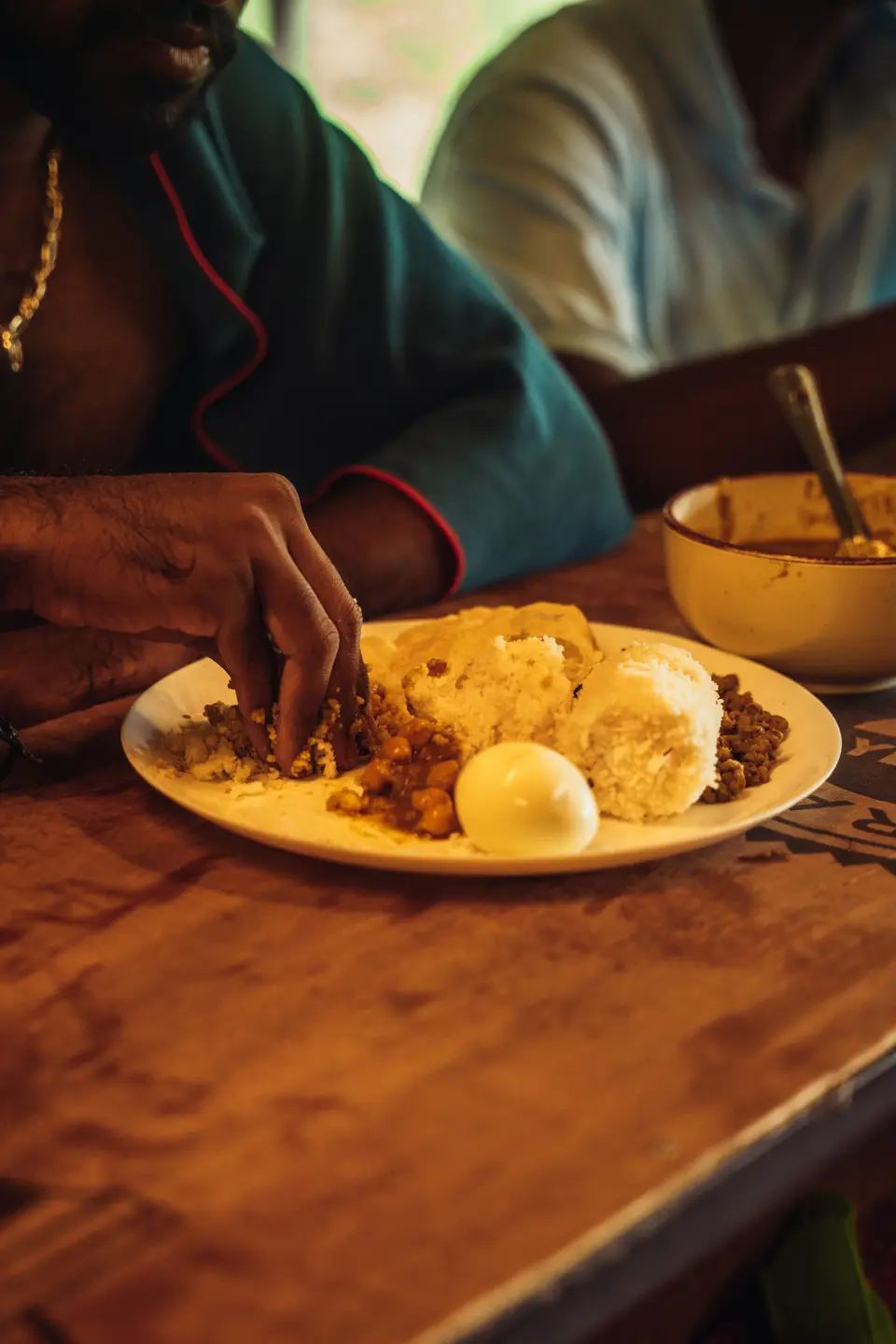 A Kerala breakfast of appam and curry being eaten by hand