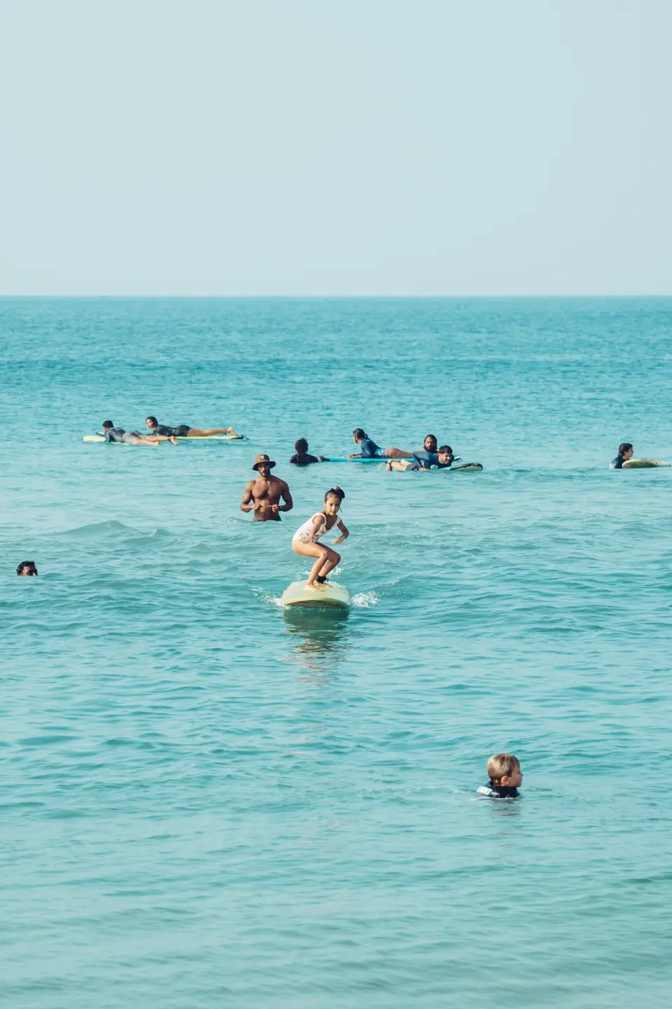 A kid standing up on their own wave