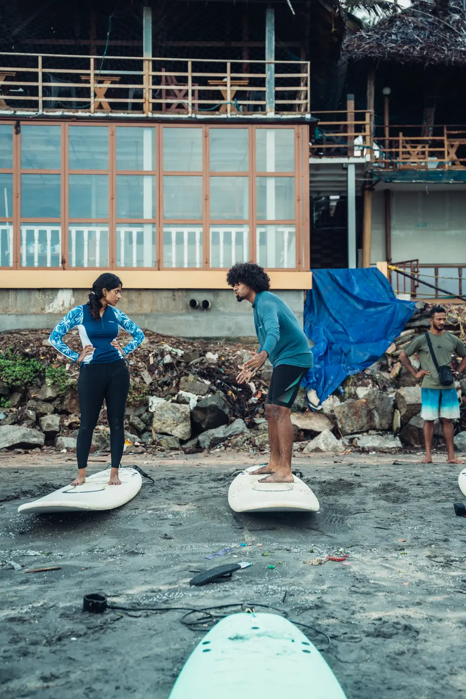 Practising on the sand, two people standing on their boards