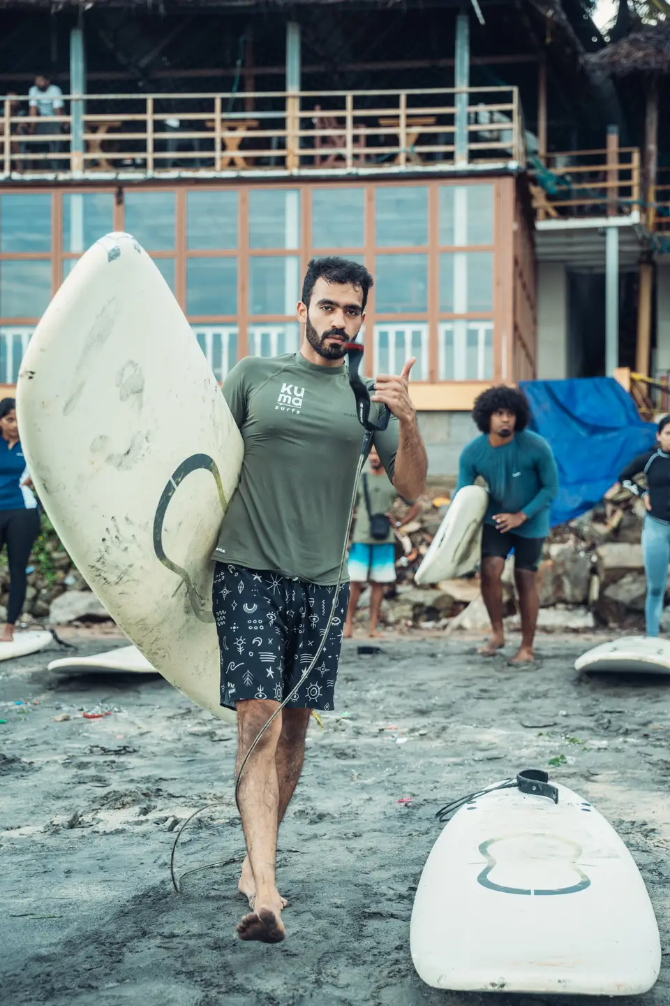 An instructor carrying boards down to the water before a class