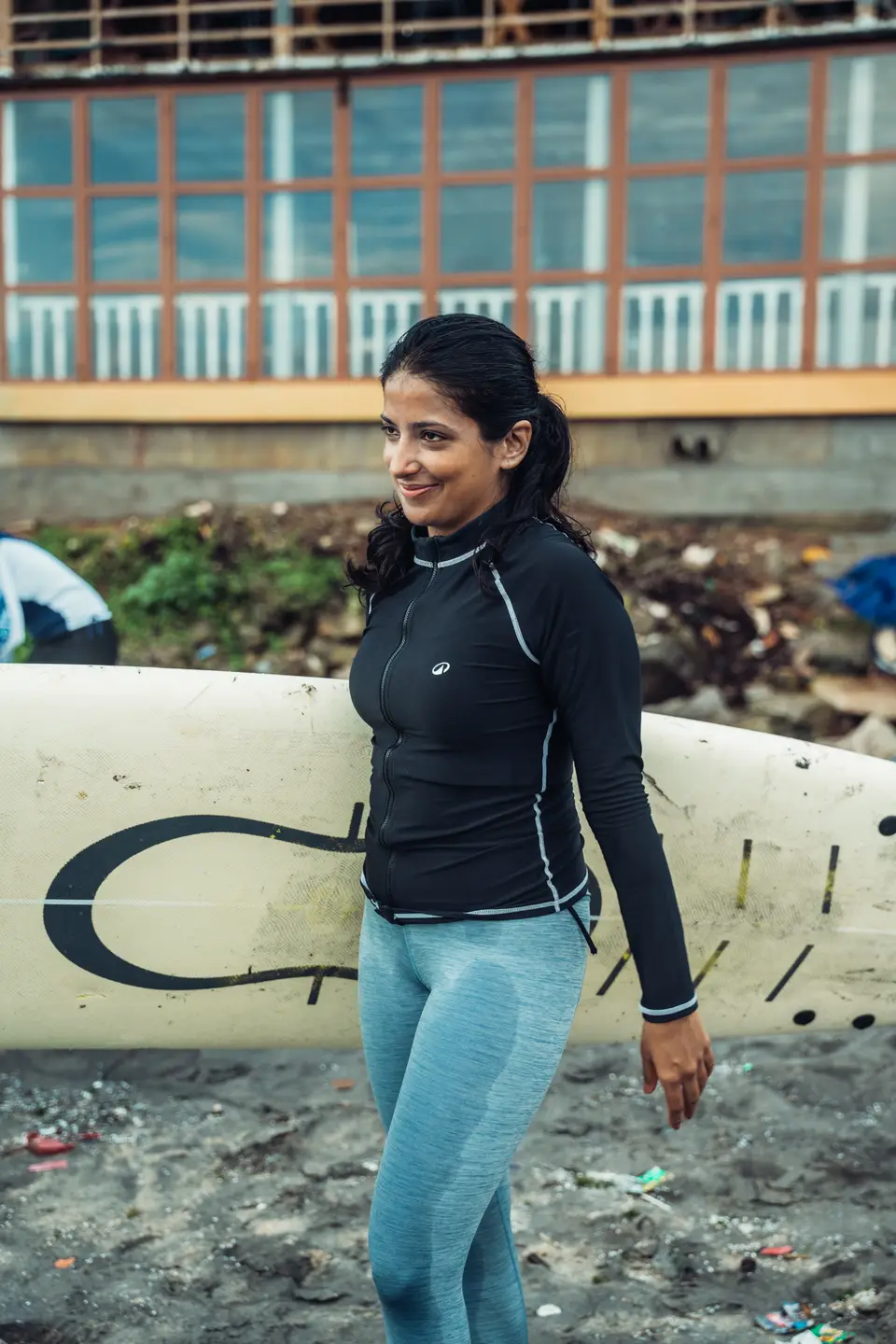 Smiling on the sand, a white board behind her
