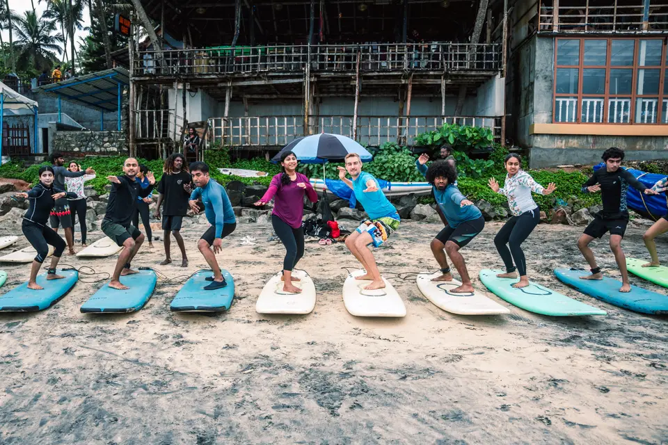 A surf class practising the pop-up on the sand at Edava beach, Varkala