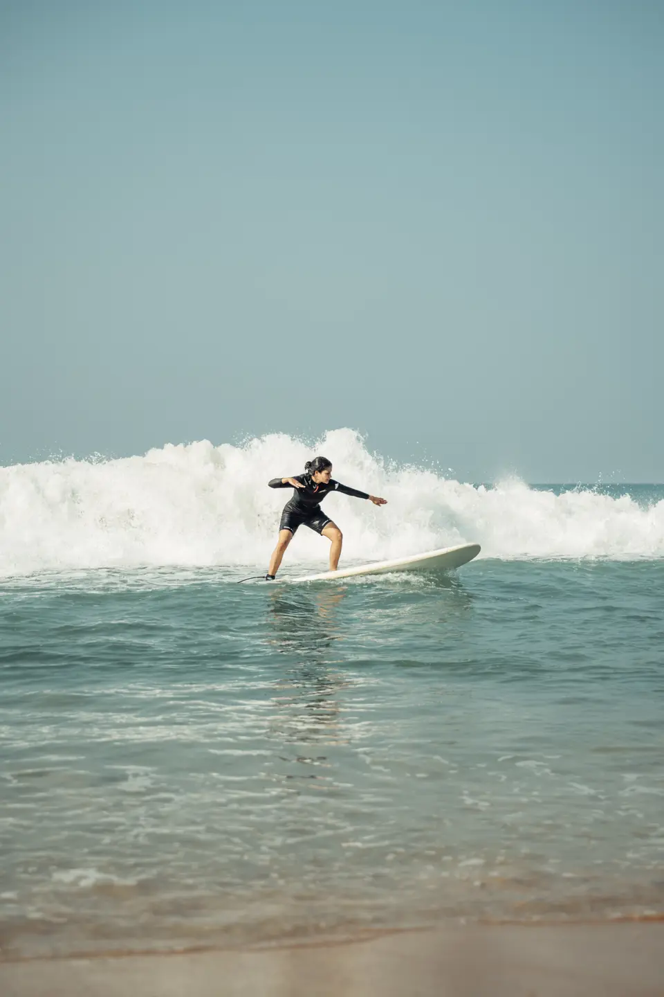 Up on a longboard, arms out, riding the whitewash in