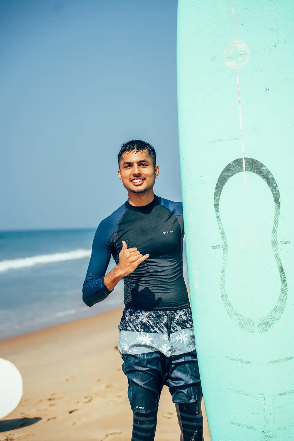 A Kuma instructor on the beach at Edava with a board
